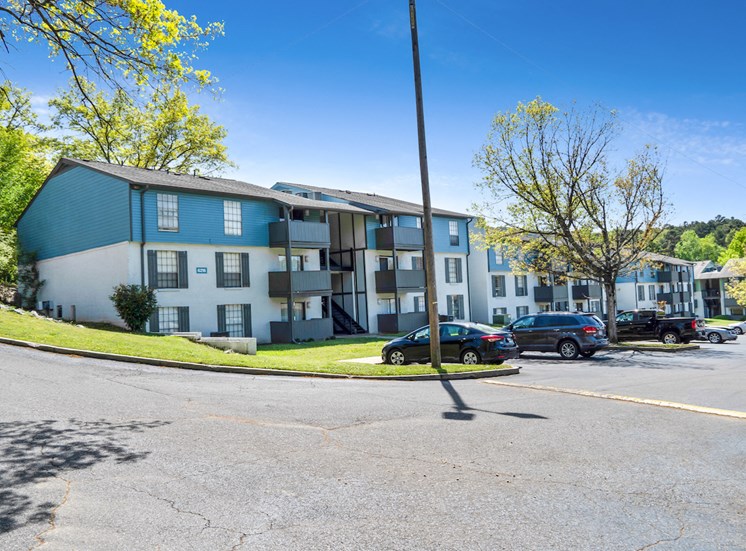 newly painted apartment building exteriors with ample parking and mature landscaping